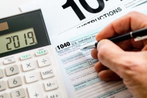 A person filling out an irs form 1 0 4 0.